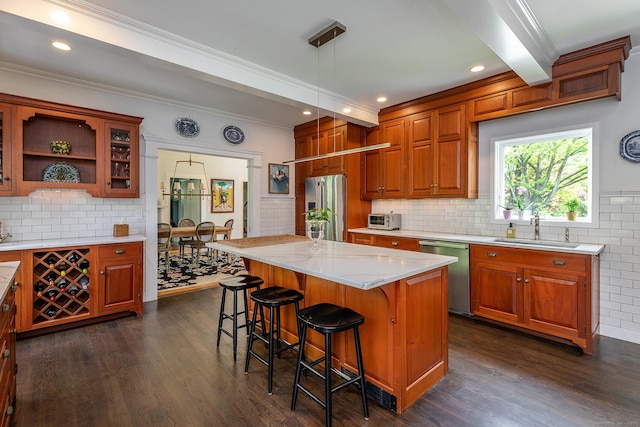 118 S St, Litchfield, CT 06759 - kitchen featuring stainless steel appliances, a sink, a breakfast bar area, dark wood-style flooring, and ornamental molding