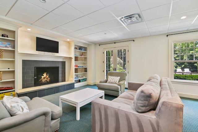 42 Morningside Dr S, Westport, CT 06880 - living area with carpet, baseboards, a tiled fireplace, built in features, and a paneled ceiling