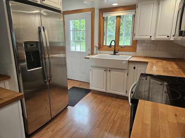 16 Walnut St (Pawcatuck), Unit Pawcatuck Stonington, CT 06379 - kitchen featuring stainless steel fridge, butcher block countertops, a sink, white cabinets, and light wood-style floors