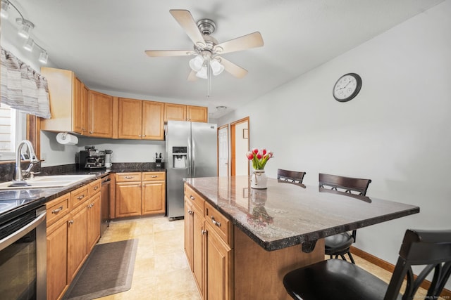 18 Kimberly Dr, Enfield, CT 06082 - kitchen featuring stainless steel appliances, a sink, a kitchen bar, ceiling fan, and dark stone countertops