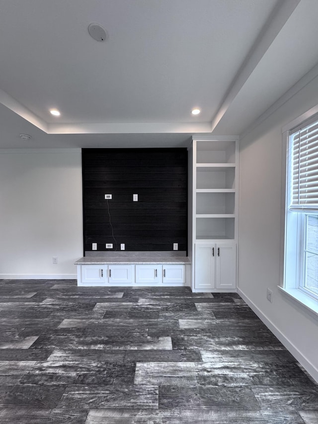 7 Middle Ter, Vernon, CT 06066 - unfurnished living room featuring dark wood-type flooring, a raised ceiling, baseboards, recessed lighting, and built in shelves
