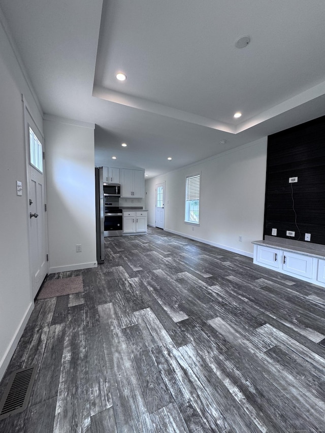 7 Middle Ter, Vernon, CT 06066 - unfurnished living room featuring dark wood-type flooring, a tray ceiling, recessed lighting, and baseboards