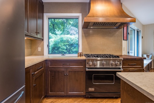 291 Peddlers Rd, Guilford, CT 06437 - kitchen featuring stainless steel appliances, custom exhaust hood, light countertops, dark brown cabinets, and decorative backsplash