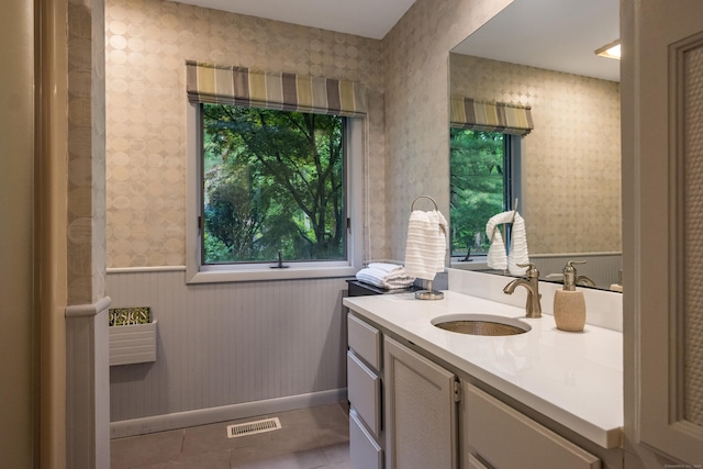 291 Peddlers Rd, Guilford, CT 06437 - bathroom with wallpapered walls, vanity, tile patterned floors, a wainscoted wall, and baseboards