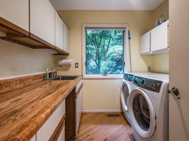 291 Peddlers Rd, Guilford, CT 06437 - laundry room with separate washer and dryer, cabinet space, light wood finished floors, and baseboards