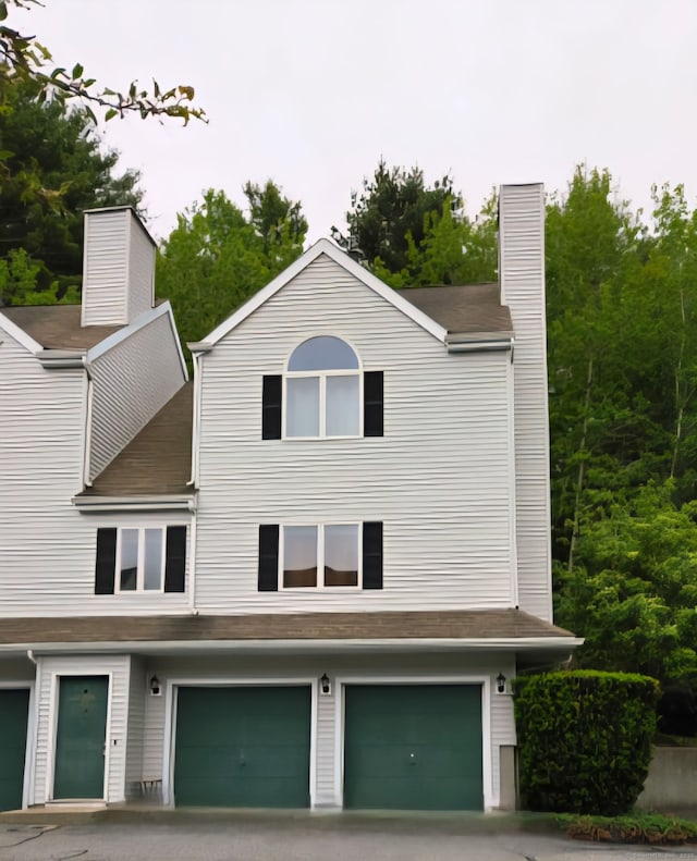 605 Whetstone Mls Unit 605, Killingly, CT 06241 - view of front of house featuring an attached garage, a chimney, and driveway