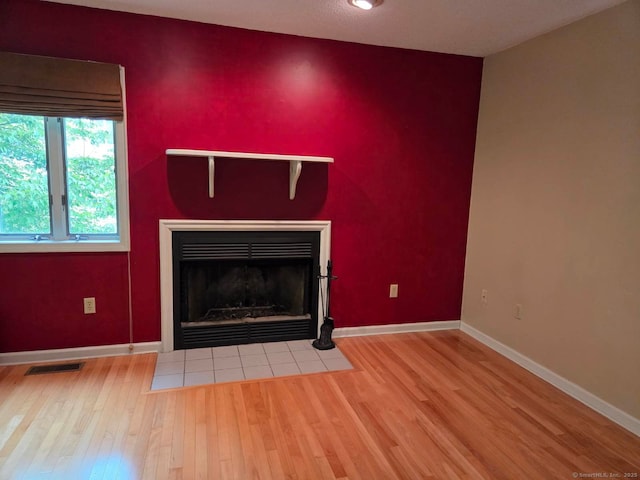 605 Whetstone Mls Unit 605, Killingly, CT 06241 - detailed view of wood finished floors, baseboards, a tiled fireplace, and an accent wall