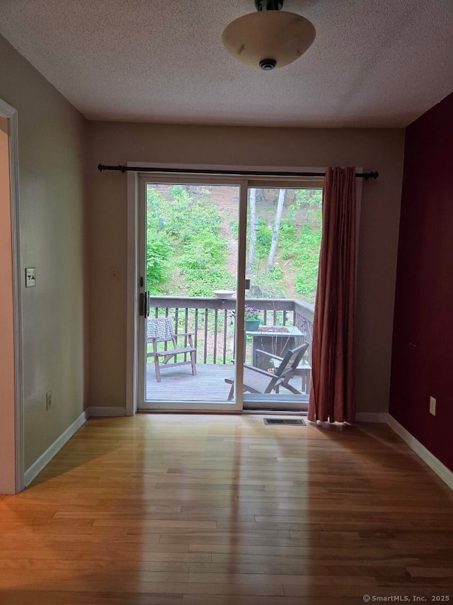 605 Whetstone Mls Unit 605, Killingly, CT 06241 - spare room with wood finished floors, a textured ceiling, and baseboards