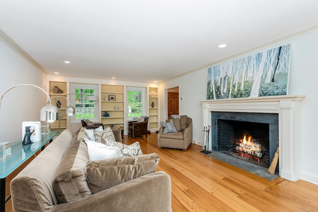 1208 Smith Ridge Rd, New Canaan, CT 06840 - living area with ornamental molding, a fireplace with flush hearth, light wood-type flooring, built in features, and recessed lighting