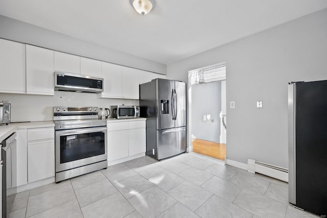 5 Stevens St, Bridgeport, CT 06606 - kitchen with stainless steel appliances, baseboard heating, light countertops, and white cabinets