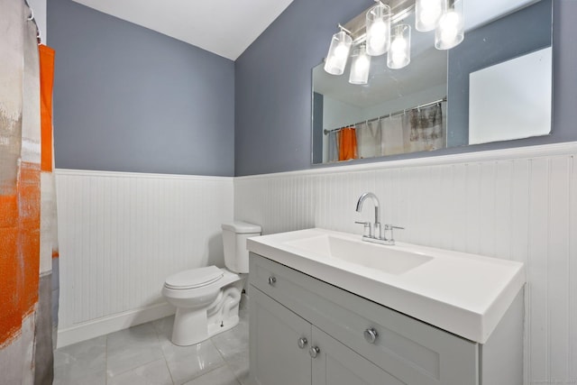 5 Stevens St, Bridgeport, CT 06606 - full bathroom with a wainscoted wall, vanity, toilet, tile patterned floors, and a chandelier