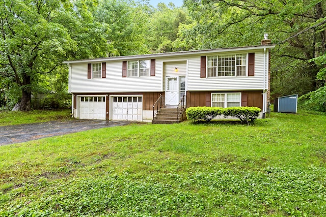 108 Gallivan Ln, Montville, CT 06382 - raised ranch featuring asphalt driveway, a chimney, a front lawn, an attached garage, and a wooded view