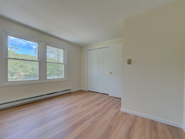 33 Homestead Rd, Ledyard, CT 06339 - unfurnished bedroom featuring light wood-type flooring, a baseboard heating unit, baseboards, and a closet