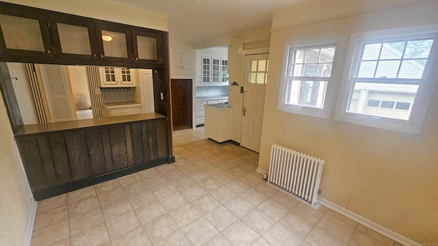19 Weymouth Rd, Enfield, CT 06082 - kitchen with radiator, plenty of natural light, baseboards, and glass insert cabinets