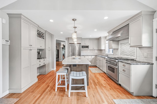 59 Ledyard Rd, West Hartford, CT 06117 - kitchen featuring high end appliances, a sink, a kitchen island, a breakfast bar, and wall chimney range hood