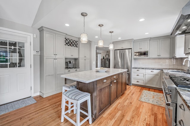 59 Ledyard Rd, West Hartford, CT 06117 - kitchen with high end appliances, light wood finished floors, a sink, light stone counters, and recessed lighting
