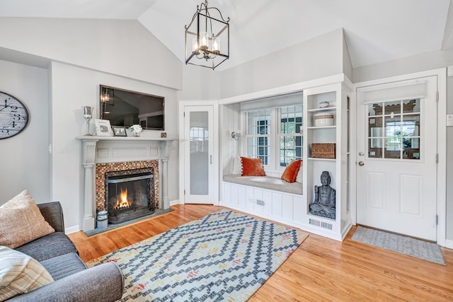 59 Ledyard Rd, West Hartford, CT 06117 - living room with plenty of natural light, wood finished floors, a chandelier, a warm lit fireplace, and high vaulted ceiling