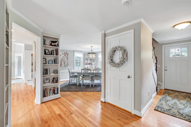 59 Ledyard Rd, West Hartford, CT 06117 - entryway featuring light wood finished floors, a chandelier, baseboards, and crown molding