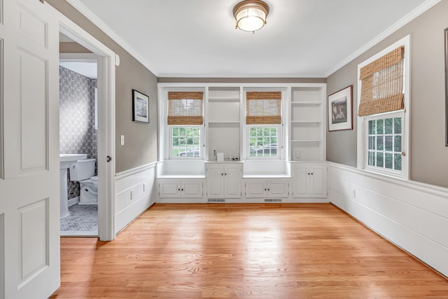 59 Ledyard Rd, West Hartford, CT 06117 - unfurnished room with wainscoting, crown molding, light wood-style floors, and a decorative wall