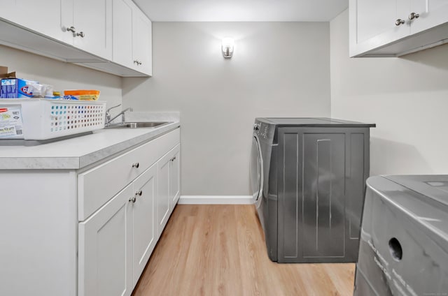 59 Ledyard Rd, West Hartford, CT 06117 - laundry area featuring washing machine and dryer, light wood-type flooring, cabinet space, and baseboards