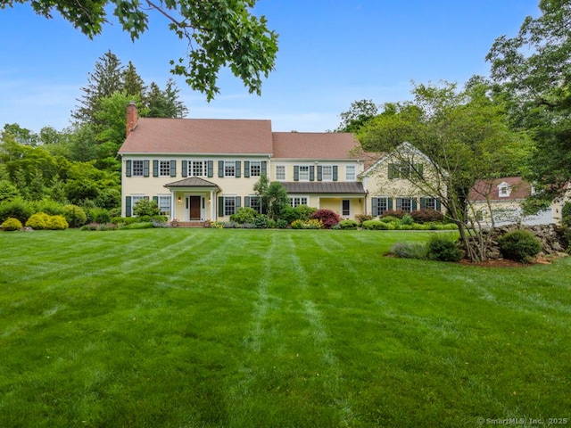 96 Norrans Ridge Dr, Ridgefield, CT 06877 - colonial-style house with a chimney, a front yard, a standing seam roof, and a metal roof