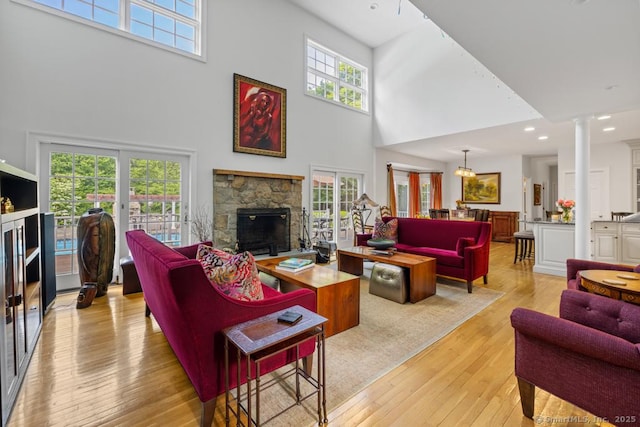 96 Norrans Ridge Dr, Ridgefield, CT 06877 - living area featuring a towering ceiling, a fireplace, ornate columns, light wood-style flooring, and recessed lighting