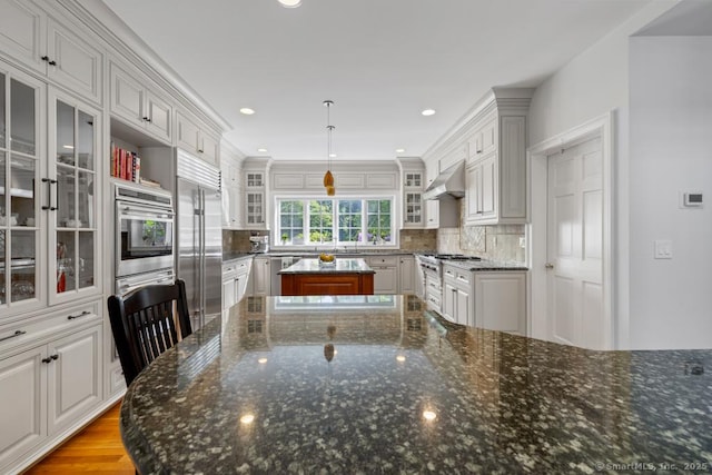 96 Norrans Ridge Dr, Ridgefield, CT 06877 - kitchen featuring stainless steel appliances, under cabinet range hood, a center island, and backsplash