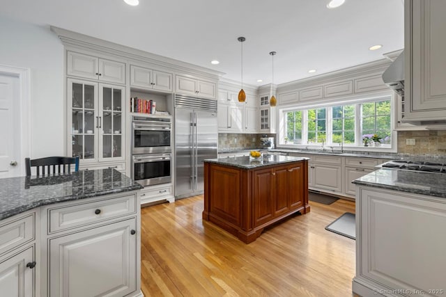 96 Norrans Ridge Dr, Ridgefield, CT 06877 - kitchen with appliances with stainless steel finishes, decorative backsplash, glass insert cabinets, light wood-style floors, and recessed lighting