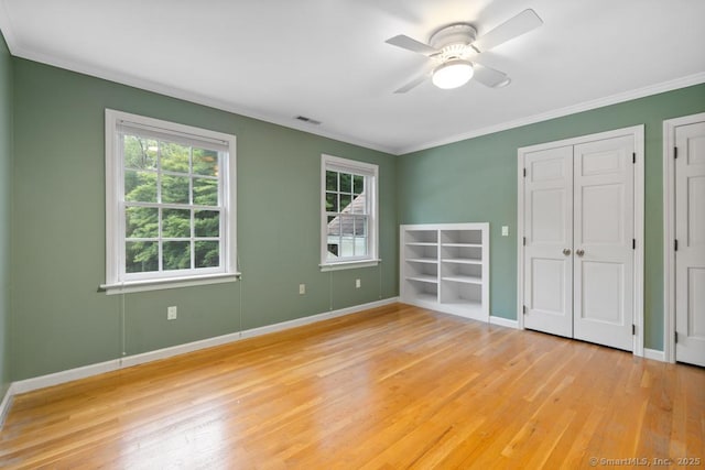 96 Norrans Ridge Dr, Ridgefield, CT 06877 - unfurnished bedroom featuring multiple windows, light wood-style floors, ornamental molding, ceiling fan, and multiple closets