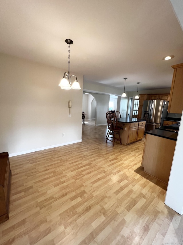 4 Cedar Grove Rd, Southington, CT 06489 - kitchen featuring arched walkways, dark countertops, light wood-type flooring, open floor plan, and a kitchen bar