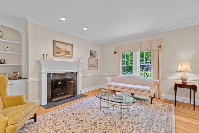 14 Withe Pass, Burlington, CT 06013 - living area featuring crown molding, wood finished floors, a tile fireplace, built in shelves, and baseboards