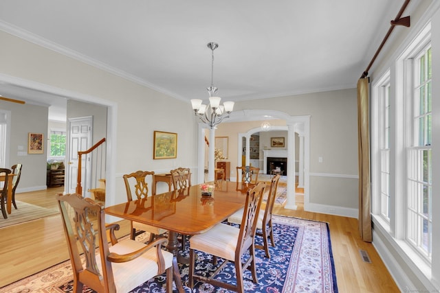 14 Withe Pass, Burlington, CT 06013 - dining space featuring light wood-style floors, crown molding, arched walkways, a chandelier, and baseboards