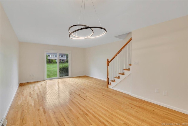 165 Hampton Ct Unit 165, Newington, CT 06111 - unfurnished living room featuring wood finished floors, stairway, baseboards, and a chandelier