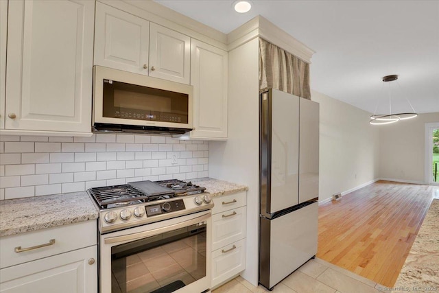 165 Hampton Ct Unit 165, Newington, CT 06111 - kitchen featuring white microwave, stainless steel gas range, freestanding refrigerator, tasteful backsplash, and light stone counters