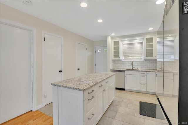 165 Hampton Ct Unit 165, Newington, CT 06111 - kitchen featuring dishwasher, a sink, decorative backsplash, glass insert cabinets, and white cabinetry