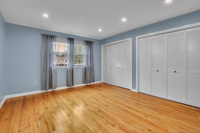 165 Hampton Ct Unit 165, Newington, CT 06111 - unfurnished bedroom featuring light wood-type flooring, baseboards, multiple closets, and recessed lighting