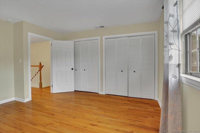 165 Hampton Ct Unit 165, Newington, CT 06111 - unfurnished bedroom with two closets, light wood-style flooring, and baseboards