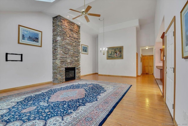 503 Dzen Way Unit 503, South Windsor, CT 06074 - living room with high vaulted ceiling, ceiling fan, light wood finished floors, a stone fireplace, and a chandelier