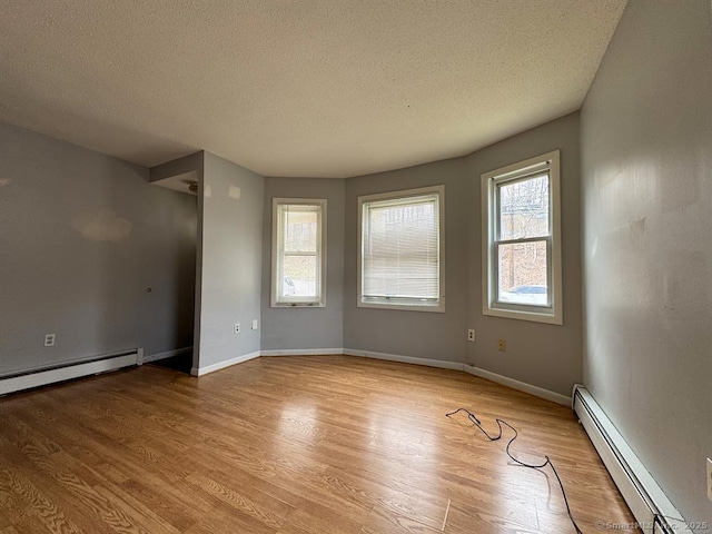 220 Kensington Ave, New Britain, CT 06051 - spare room with a baseboard heating unit, a textured ceiling, light wood finished floors, and baseboards