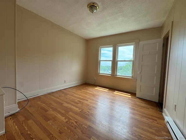 220 Kensington Ave, New Britain, CT 06051 - spare room with a baseboard heating unit, wood finished floors, a textured ceiling, and baseboards