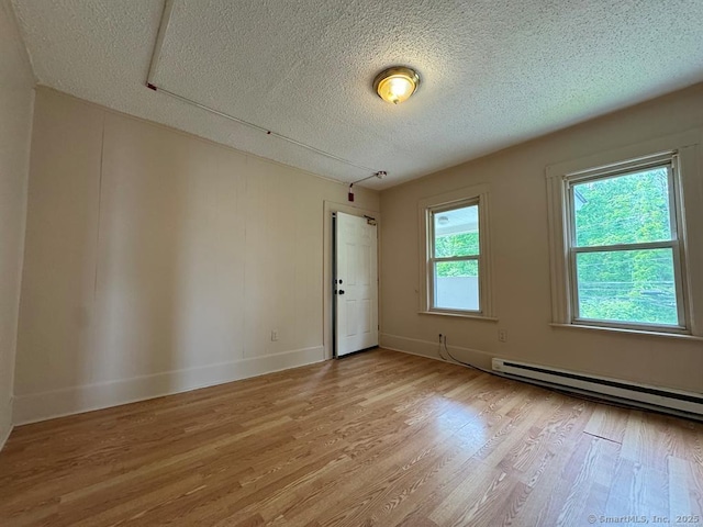 220 Kensington Ave, New Britain, CT 06051 - empty room featuring light wood-style floors, a textured ceiling, a baseboard radiator, and baseboards