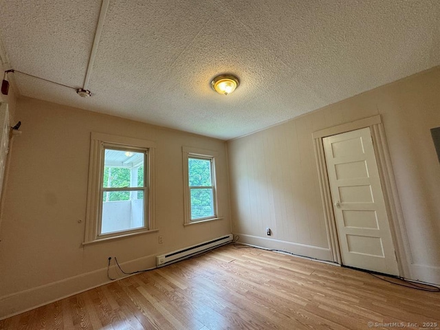 220 Kensington Ave, New Britain, CT 06051 - unfurnished room with a baseboard heating unit, light wood finished floors, baseboards, and a textured ceiling