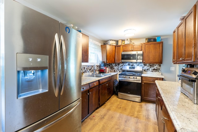 165 Scantic Meadow Rd, South Windsor, CT 06074 - kitchen featuring appliances with stainless steel finishes, a sink, backsplash, light wood-type flooring, and light countertops