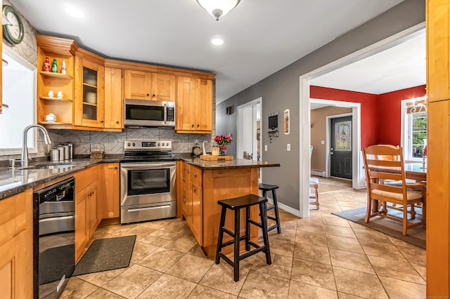 28 Blakeman Dr, Monroe, CT 06468 - kitchen with stainless steel appliances, a sink, a peninsula, decorative backsplash, and a breakfast bar