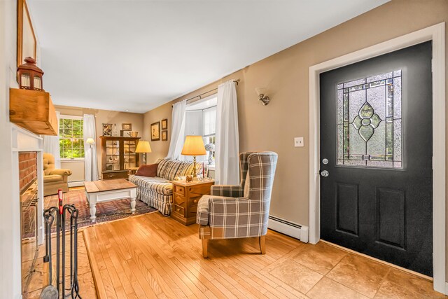 28 Blakeman Dr, Monroe, CT 06468 - foyer with a baseboard heating unit, light wood-style flooring, and a brick fireplace