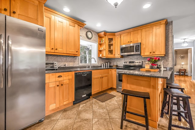 28 Blakeman Dr, Monroe, CT 06468 - kitchen featuring appliances with stainless steel finishes, a sink, a breakfast bar, decorative backsplash, and glass insert cabinets