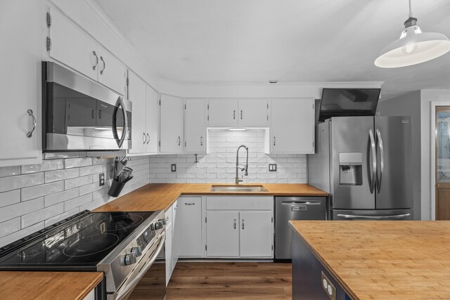 38 Rossie St, Stonington, CT 06355 - kitchen with appliances with stainless steel finishes, wood counters, white cabinetry, and decorative backsplash