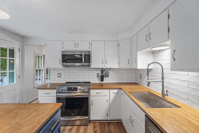 38 Rossie St, Stonington, CT 06355 - kitchen with appliances with stainless steel finishes, white cabinets, backsplash, and butcher block counters