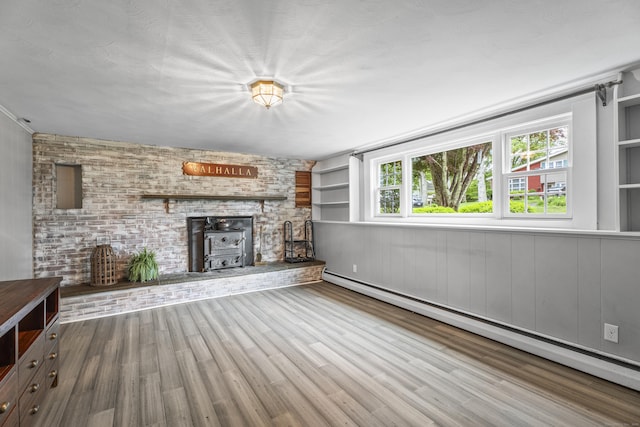 38 Rossie St, Stonington, CT 06355 - unfurnished living room with a baseboard radiator, a wood stove, and wood finished floors