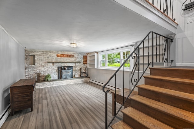 38 Rossie St, Stonington, CT 06355 - unfurnished living room with stairs, a baseboard radiator, wood finished floors, and a fireplace